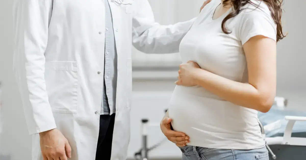 eine schwangere patientin bei einem prädiagnostik arzttermin beide stehend